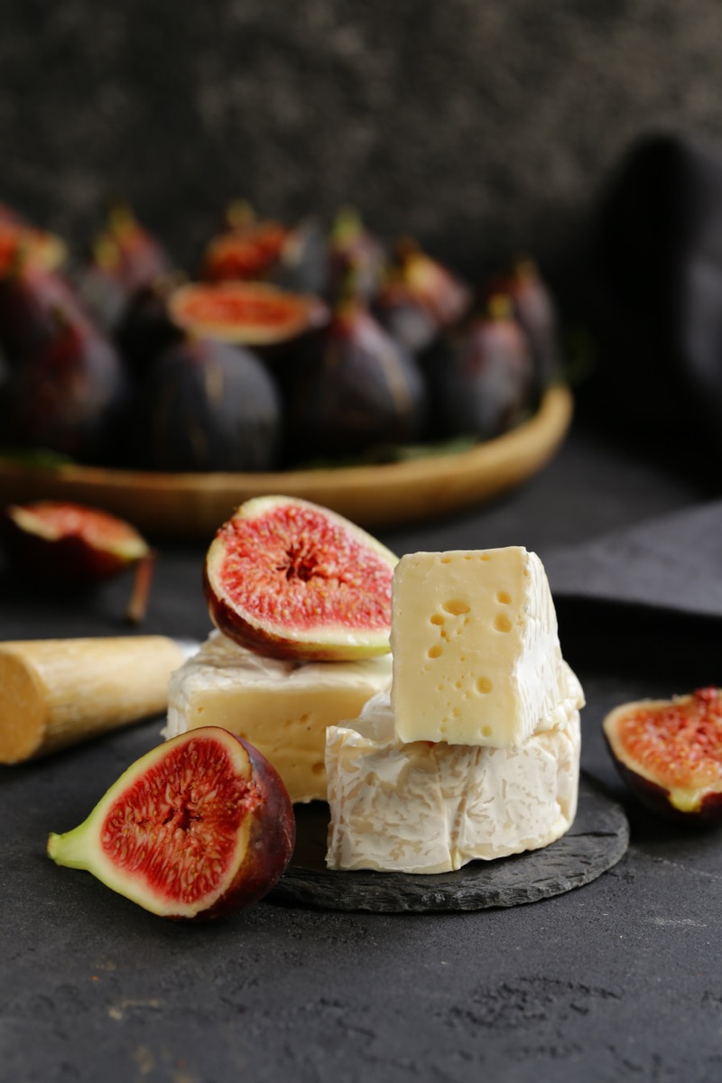 Elegant cheese and fig arrangement on a dark surface